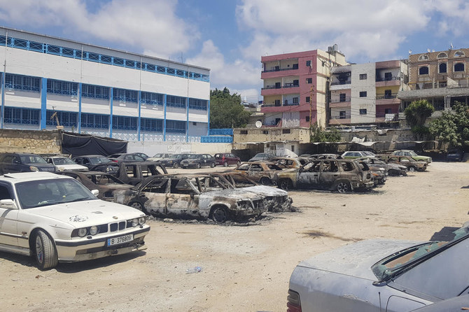 2023年8月3日、アイン・エル・ヒルウェ難民キャンプにあるUNRWAの学校の前で、パレスチナの派閥間の致命的な武力衝突で燃やされた数十台の車の残骸。（ファイル/AP）