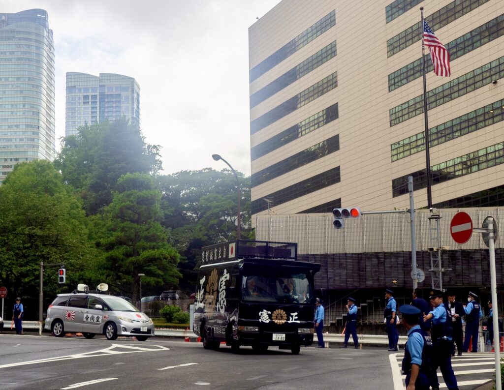 抗議者たちは屋根にスピーカーをつけた黒いトラックで大使館の前を何時間も行ったり来たりした。警察が警備する中、彼らは拡声器を使って大声で謝罪を求めた。(ANJ)