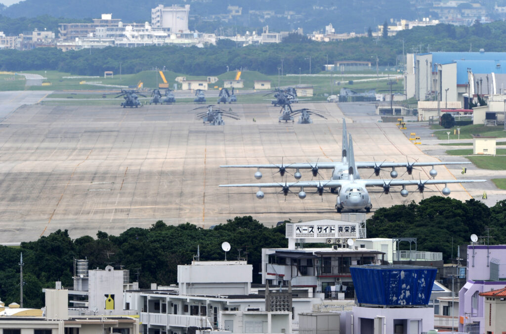 集会は、墜落事故で焼け焦げたアカギの木の前で開かれ、教職員、学生ら約５０人が参加した。(AFP)