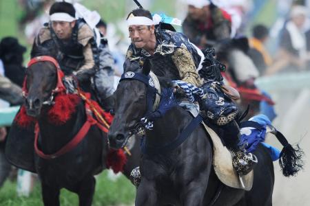 2012年7月29日、福島県南相馬市で開催された「相馬野馬追」で鎧兜を纏う人々。（AFP）