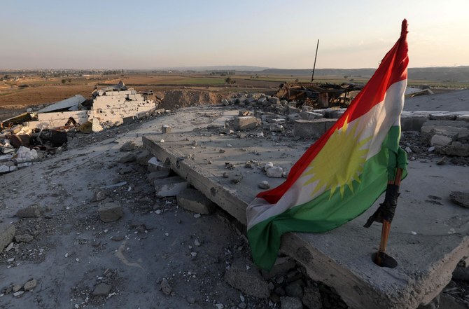 資料写真には、報道にあった昨年11月の、イラクのクルド人自治区キルクール北部の町アルティンコプリ（Perdi）付近で、イランのロケット弾攻撃による破壊状態の中にあるクルドの旗が写っている（AFP）