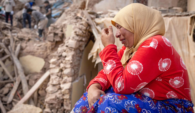 2023年9月8日に発生したマグニチュード6.8の大地震の余波を受け、モロッコ中部アミズミズ近郊のイミ・ンタラ（Imi N'Tala）村で、破壊された建物のがれきのそばに座り込む女性。2023年9月10日。（AFP）