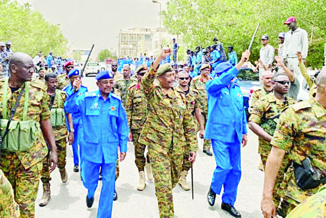ポートスーダンの1地域を視察する際に、軍の側近と士官に囲まれ、人々に手を振るスーダン軍トップのアブドゥルファッターフ・ブルハン・アブドゥルラフマーン・ブルハン将軍。（AFP）