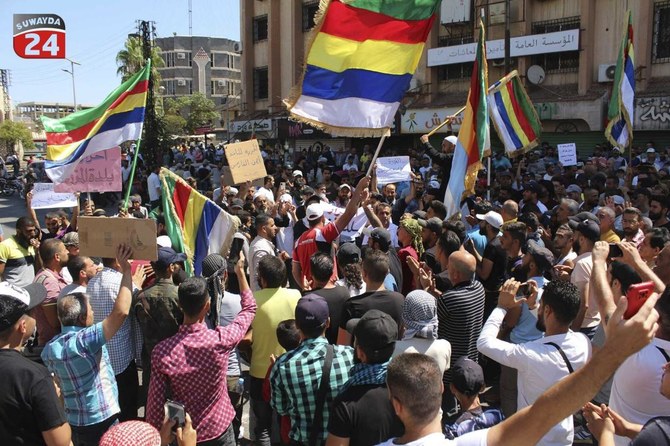 2023年8月27日、『スワイダ24』が公開した写真。シリア南部の都市スワイダで、ドゥルーズ派の旗を振って抗議する人々。（AP）