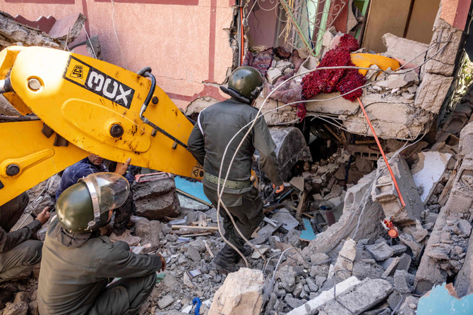 2023年9月9日にモロッコで発生した大地震の後、アル・ホウズ州Moulay Brahim村で、小さな掘削機を使用し、倒壊した家の瓦礫の下から生存者を捜索する救助隊員たち。（AFP）