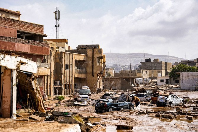 上の写真は、暴風雨ダニエルの影響で破壊された車両と損傷した東部デルナの建物。(リビア首相官邸/AFP通信）