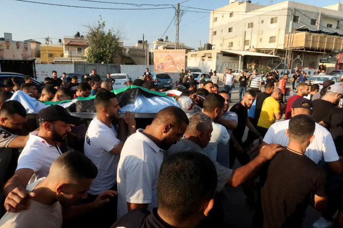 イスラエル占領下のヨルダン川西岸地区エリコで葬儀が行われた。イスラエル軍の襲撃で死亡したパレスチナ人の遺体を運ぶ弔問客。（ロイター）