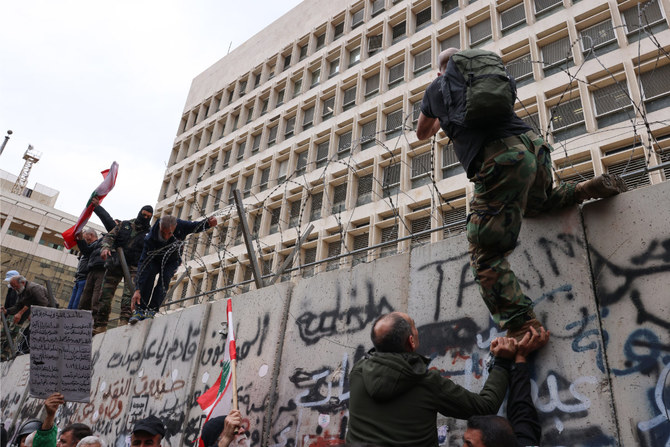 年金に対するインフレ調整を要求するデモの最中、レバノン中央銀行の外で有刺鉄線バリケードを取り除こうとする退役軍人ら。2023年3月30日、ベイルート。（AFP/ファイル写真）