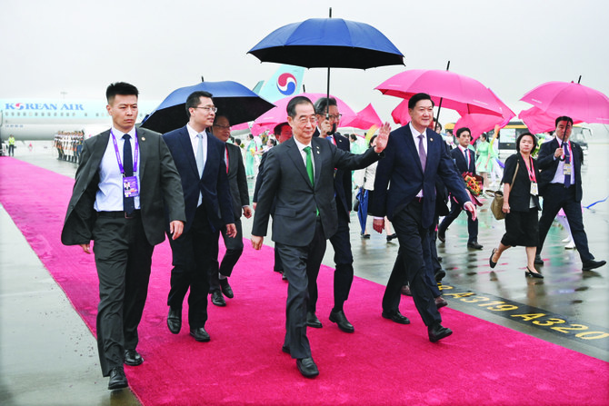 2023年9月23日土曜、中国・杭州に到着し、パフォーマーたちからの歓迎を受け、手を振る韓国首相、韓悳洙氏（中央）。（AP通信）