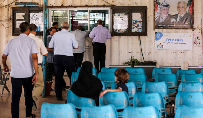 ガザ地区北部のベイト・ハヌン近郊にあるイスラエルのエレズ検問所で、パレスチナ当局の職員に旅行書類の手続きをする人を待つパレスチナ人たち。（AFP 資料写真）