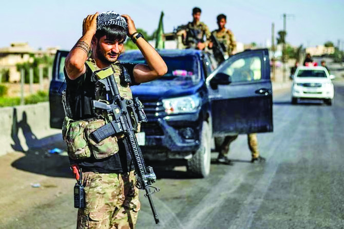 シリア北東部デリゾール県で仲間と行動するシリア民主軍の戦闘員。（AFP通信）