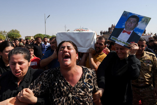 イラク・ハムダニヤの結婚式場で起きた火災による犠牲者の葬儀で、弔問者らが棺を運んでいる。（ロイター通信）