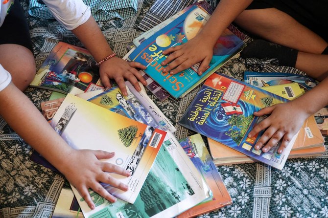 2023年9月21日、3人の幼い子供たちを公立学校に通わせる余裕すらなくなるのではないかと心配する主婦のファラ・クーバルさんの子供2人が、ベイルートの自宅のアパートで自分たちの練習帳を確認している。(AFP通信)
