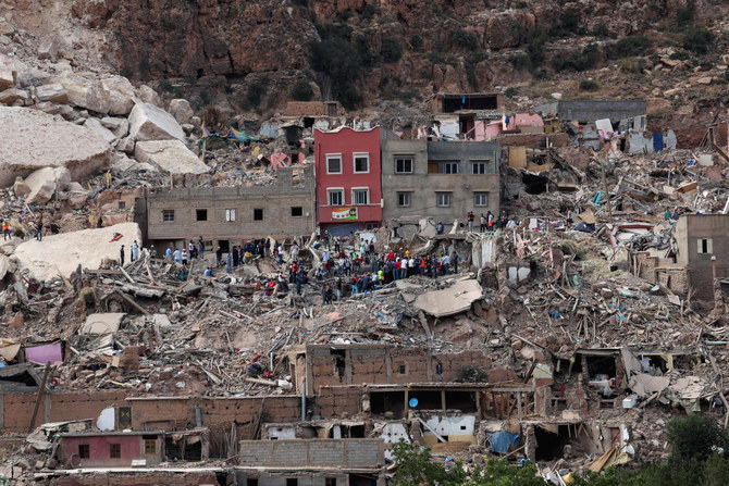 2023年9月12日、モロッコで発生した壊滅的な地震で荒廃したイミ・ンタラ村の瓦礫の上に立っている人々。（ロイター）