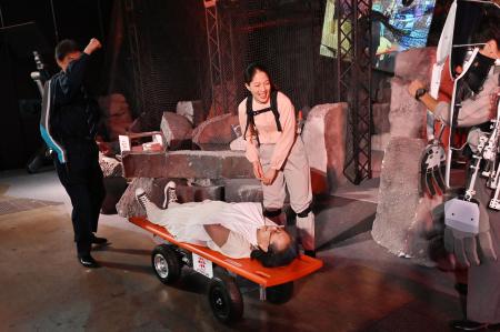 2023年10月25日、東京で開催されたジャパンモビリティショーのプレスデーで、アトラックラボが製作したストレッチャーロボットで搬送される女性。（AFP）