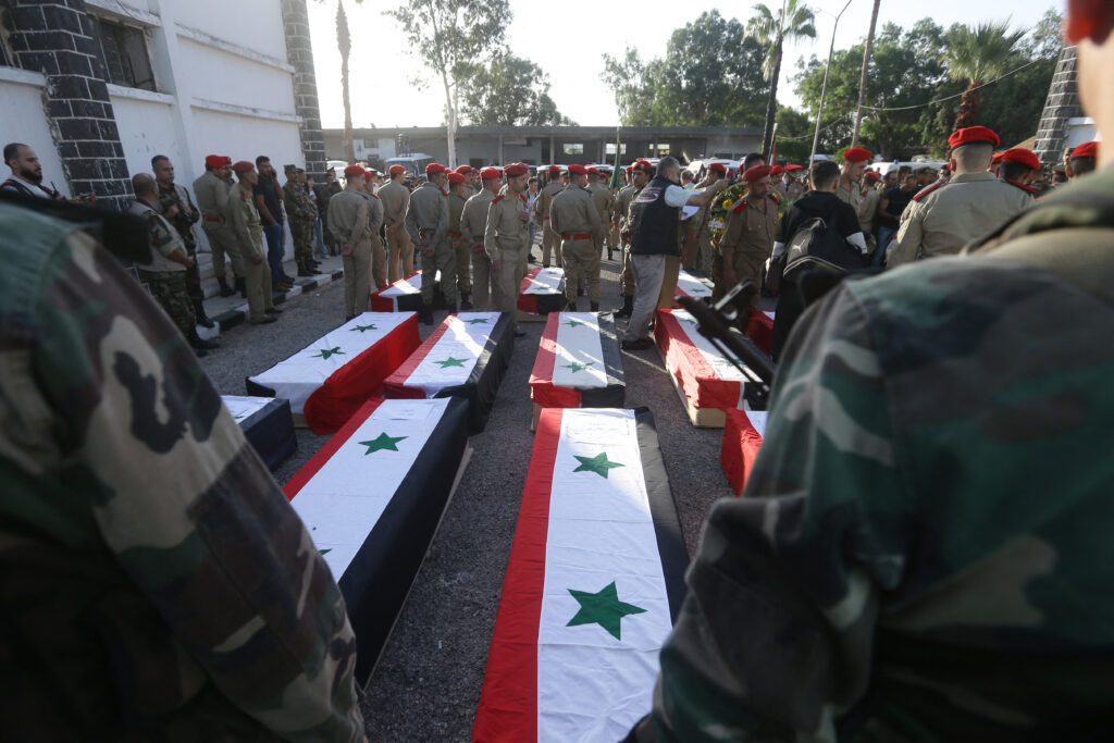 2023年10月6日、シリア軍学校を狙った無人機攻撃の犠牲者の葬儀で、政府軍支配下のホムスにある病院の外で棺を並べるシリア軍兵士。(AFP＝時事）
