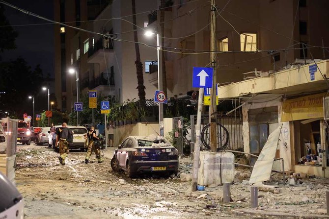 ガザ地区から発射されたロケット弾が着弾した後、通りを歩くイスラエルの治安部隊。2023年10月7日、テルアビブ。（AFP）