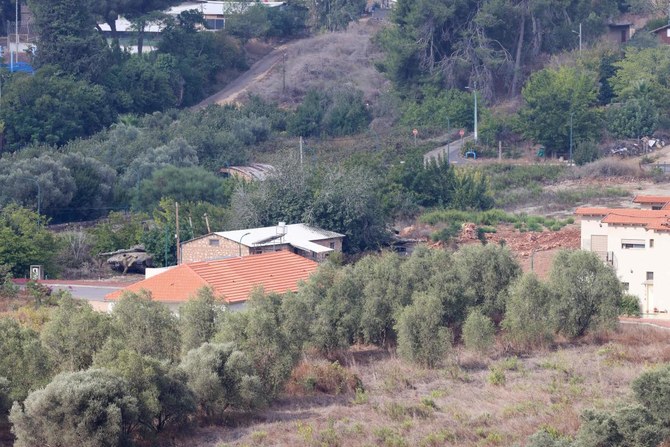 2023年10月10日、レバノン南部のキアム平原から撮影された、イスラエル北部の町メトゥーラに停車中の軍用装甲車。(AFP＝時事）