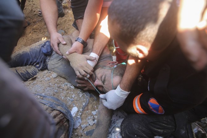 ガザ地区ラファで、イスラエル軍の空爆を受け、破壊された建物の瓦礫から負傷者を救出するパレスチナ人。(AP)