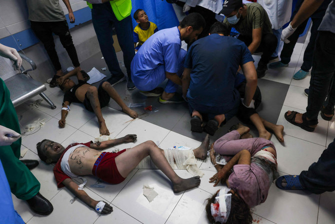 2023年10月11日、ガザ市街にあるアル・シファ病院で、イスラエル軍の空爆によって負傷した子どもたちの治療にあたる医療従事者（写真提供：モハメド・アベド / AFP）