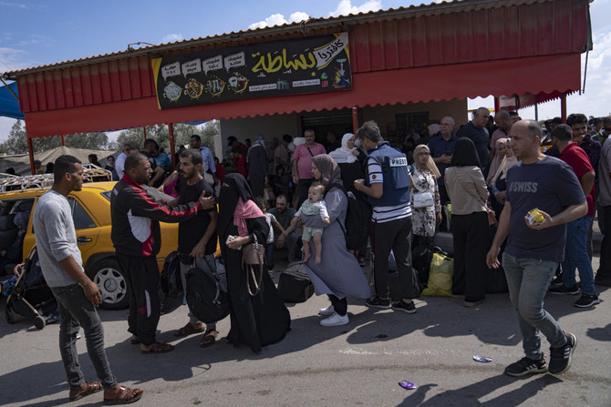 エジプトへの入国を待つパレスチナ人ら。2023年10月16日、ガザ地区のラファ国境検問所。（AP）