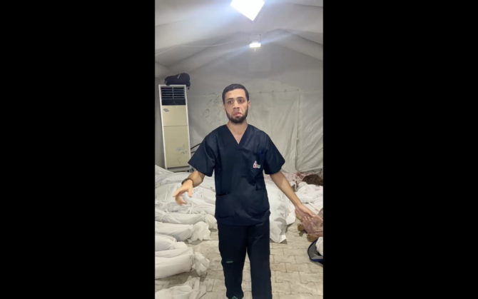 アル・アハリ病院爆撃での遺体を指差すモハメド・ゴネイム医師。(スクリーンショット）