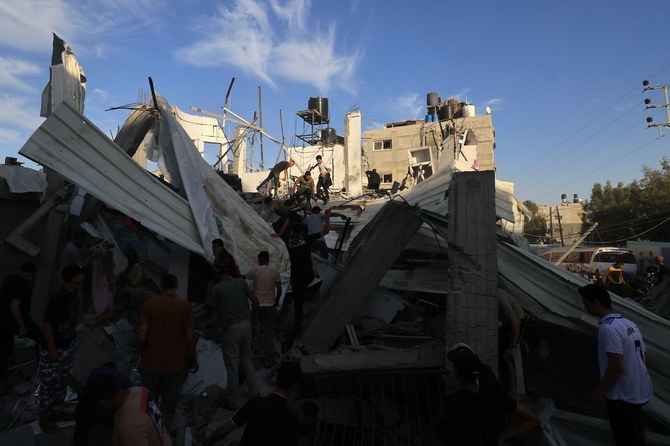 2023年10月21日、ガザ地区南部のハーン・ユーニスにある国連パレスチナ難民救済事業機関（UNRWA）の学校付近で、イスラエル軍による空爆の後、瓦礫を調べるパレスチナ人。(AFP＝時事）