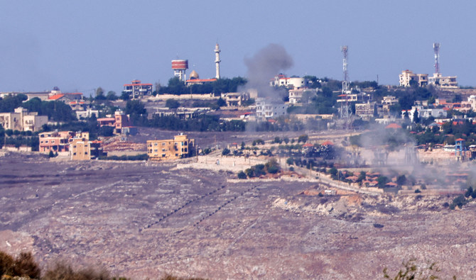2023年10月25日、イスラエルのモシャブであるアヴィヴィムの向かい側、レバノン南部のマルーン・アル・ラス村でイスラエルが砲撃を行う最中、建物の上空に煙が立ち上っている様子。（AFP通信/ファイル）