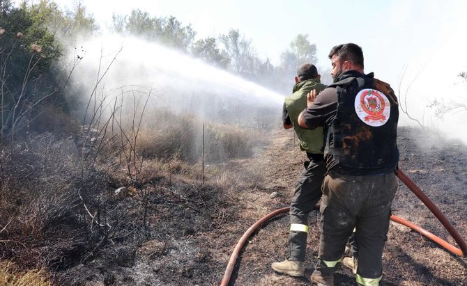 2023年10月26日、イスラエルとの国境に近いレバノン南部のアイタ・アル・シャーブでイスラエルからの砲撃後に発火したと伝えられている森林火災を消火するレバノンの民間防衛ボランティア。（AFP）