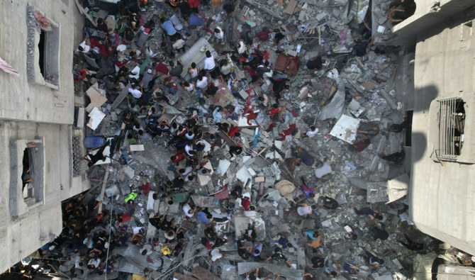 ヌセイラト難民キャンプにて、イスラエルによるガザ地区への爆撃から逃れた生存者を探すパレスチナ人。(AFP)
