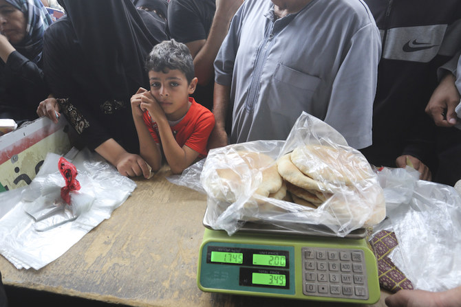 2023年10月29日日曜日、ガザ地区への爆撃が続く中、ラファでパンを買おうと待つパレスチナ人たち。（AP）