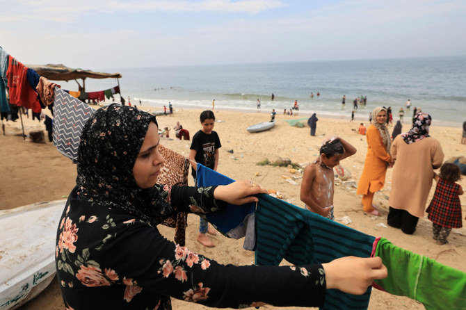 2023年10月29日、イスラエル軍による新たな侵攻のさなか、ガザ地区南部ディールバラフのビーチ沿いで、真水と電気の不足により海水で洗った洗濯物を干すパレスチナ人女性。(AFP)