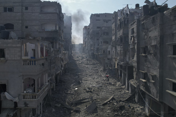 イスラエルによる空爆を受け燻っている建物の間の通りに散乱している瓦礫。2023年10月11日、ガザ地区のジャバリヤ。(AP)