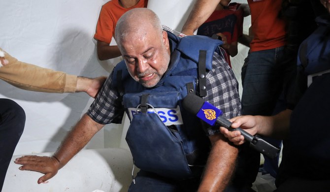 ガザ南部のアルアクサ病院で、イスラエル軍の空爆で妻とともに死亡した3人の子どものうち1人の遺体を悼むアルジャジーラのWael Al-Dahdouh特派員。(AFP)