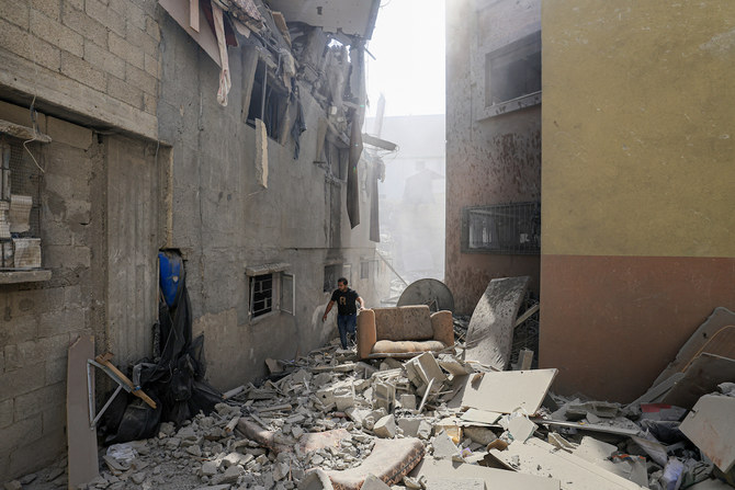 2023年10月14日、ガザ地区南部でイスラエル軍の空爆を受け、建物の被害を調査するパレスチナ人男性。（AFP）