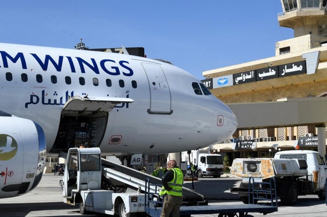 空港再開の翌日、アレッポ空港に着陸した航空機から荷物を降ろす従業員たち(2023年3月11日撮影)(AFP)