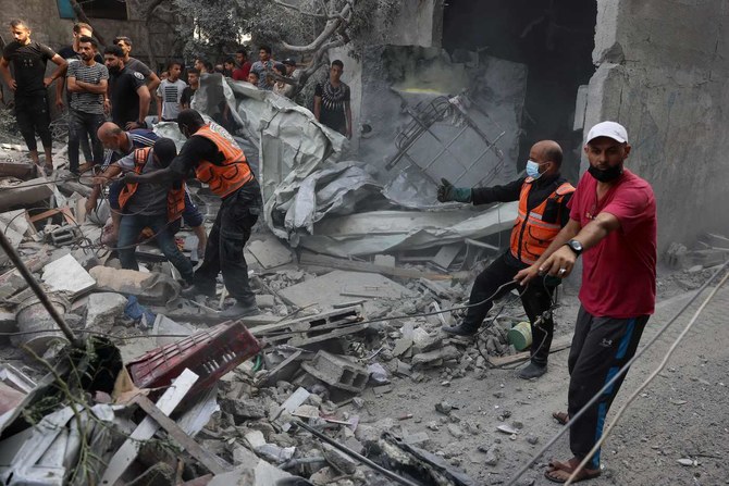 2023年10月22日、イスラエルによるガザ地区南部ラファへの空爆で破壊された家屋のがれきの下で、犠牲者や生存者を探す救助隊員。（AFP）