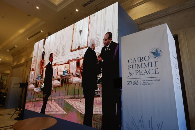 2023年10月21日、エジプトのアブドゥルファッターハ・エルシーシ大統領がカイロで主催する国際会議「平和サミット」の開始に先立ち、パレスチナのマフムード・アッバース大統領がエルシーシ大統領（写真右）に迎えられる様子が大型スクリーンに映し出されている。（AFP通信）