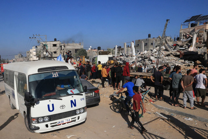 2023年11月10日、イスラエルとパレスチナの組織ハマスとの間で続く紛争の中、ガザ地区南部でイスラエルがラファを砲撃した際に破壊された建物の前を通り過ぎる国連バス。(AFP通信)