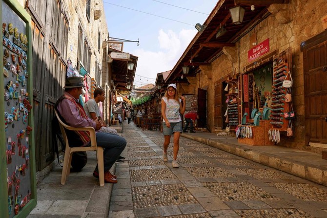 2023年11月10日、歴史的な港町ビブロスの、ほとんど閑散とした古い市場で、土産物店の前を通り過ぎる人々。（AFP）