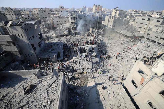 イスラエルとパレスチナ・ハマスとの戦闘が続く中、ガザ地区中央部のブレイジ難民キャンプでイスラエル軍の攻撃により破壊された建物の瓦礫を確認する人々（2023年11月2日撮影）。(AFP＝時事）