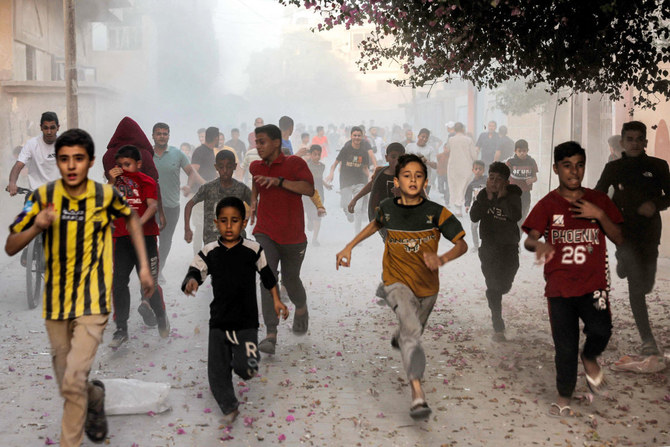 2023年11月6日、イスラエルとパレスチナの過激派組織ハマスとの戦闘が続く中、ガザ地区南部のラファでイスラエル軍の砲撃から逃げるパレスチナの子どもたち。(AFP)