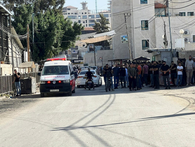 イスラエル占領下のヨルダン川西岸地区のジェニンで、イスラエルによる襲撃が行われている間、病院の前で待つパレスチナ人。（Reuters）