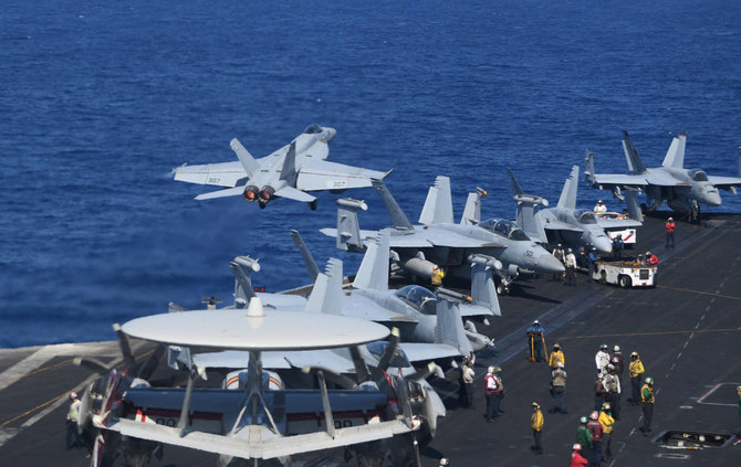 米空母セオドア・ルーズベルトでの定期訓練中、戦闘機とE-2Cホークアイを追い越して飛行する米FA-18ホーネット戦闘機。2018年4月10日、南シナ海。(AFP)
