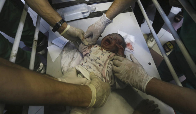 2023年11月13日、ガザ地区南部のハーン・ユーニスにあるナセル病院に到着したバラカ家の負傷したパレスチナ人女性が子供たちに囲まれている。（AFP＝時事）