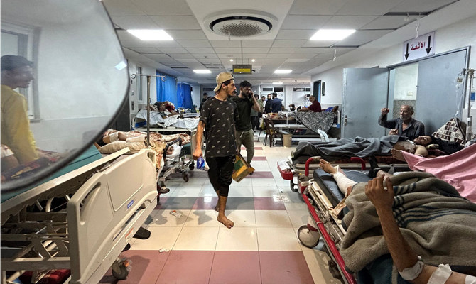2023年11月10日、イスラエルとパレスチナ組織ハマスの戦闘が続く中、ガザ市のアル・シファ病院で横たわる患者の間を歩く男性たち。（AFP通信）