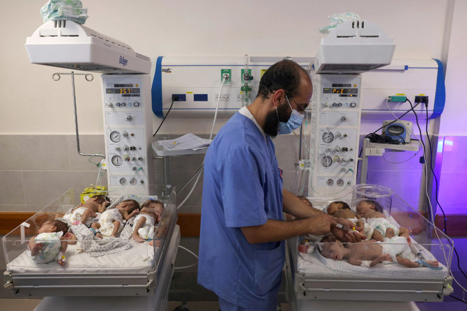 2023年11月19日、イスラエルと武装組織ハマスの戦闘が続く中、シファ病院からガザ地区南部の町ラファのエミレーツ病院に避難した未熟児の世話をするパレスチナ人医師。（AFP）