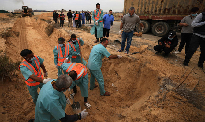 イスラエルとパレスチナ組織ハマスの間の戦闘が続く中、遺体を集団墓地に埋葬する準備をするパレスチナ人ら。2023年11月22日、ガザ地区南部のハーン・ユーニス墓地。（AFP）