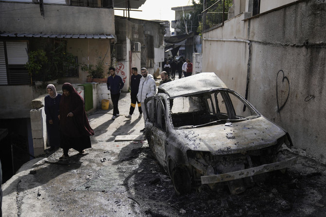 2023年11月22日、ヨルダン川西岸地区のトルカレムの町で、軍の襲撃後にイスラエル軍の攻撃現場を視察するパレスチナ人。（AP）