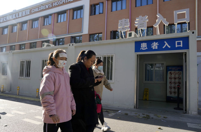 2023年11月24日金曜日、北京で「患者入口」の看板を掲げた小児病院の前を通り過ぎる人たち（AP通信）